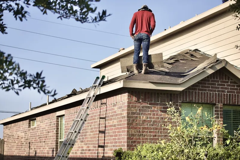 Professional roofer working on a residential roof in Bristol Manor